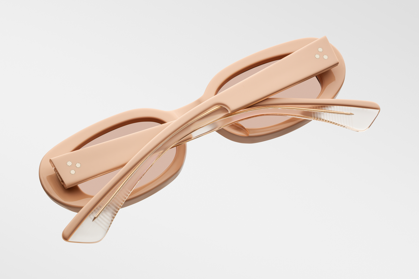 Close-up side view of Jacques Marie Mage Besset Dust Suede temple—8 mm cured matte orange‑peach cellulose acetate, light-gold arrowhead pin, light-gold lever wirecore, and tension‑secured 7‑barrel hairline‑engraved hinge