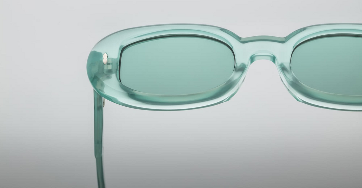 Side close-up of Jacques Marie Mage Besset Piscine temple showcasing custom double‑laminated acetate, exposed silver wirecore with hairline engraving, and precision-engineered silver tension-secured 7‑barrel hinge.