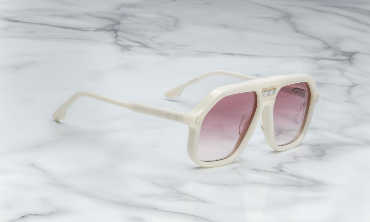 Side view of Jacques Marie Mage Casius Lotus sunglasses, showcasing the sleek, angular silhouette of the oversized frame. The design highlights the delicate gold-tone metal accents along the temples and the high-end craftsmanship. The lenses are dark and slightly curved, contributing to the bold yet refined aesthetic of the sunglasses