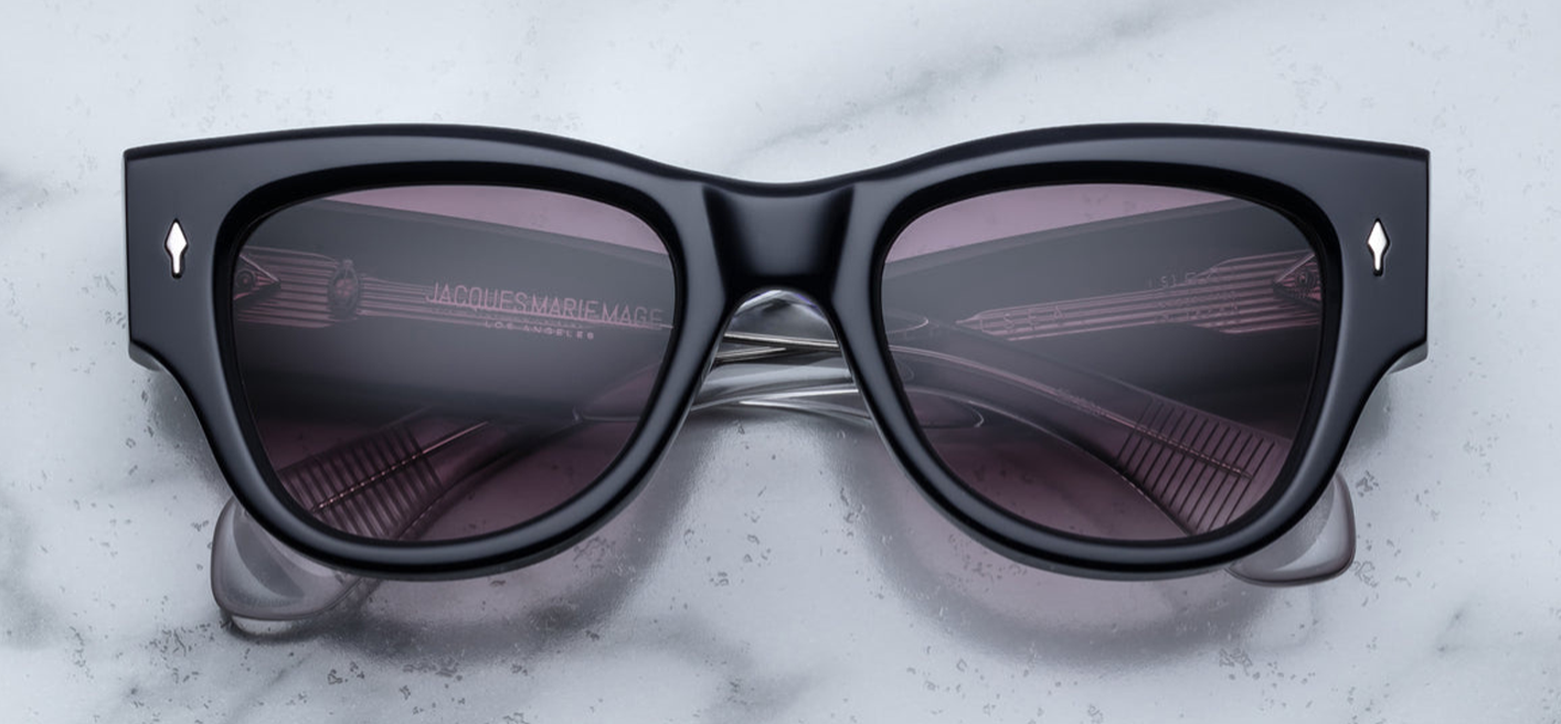 Side profile of Jacques Marie Mage Chelsea sunglasses in Skye, featuring sculpted paddle temples with exposed sterling silver cantilever wirecore, engraved detailing, and signature arrowhead front pin. Handcrafted in Japan with 10mm double-laminated pink cellulose acetate frame and custom 7-barrel hairline hinges, offering a bold, sculptural silhouette. Autumn gradient CR39 lenses provide 100% UV protection and backside anti-reflective treatment