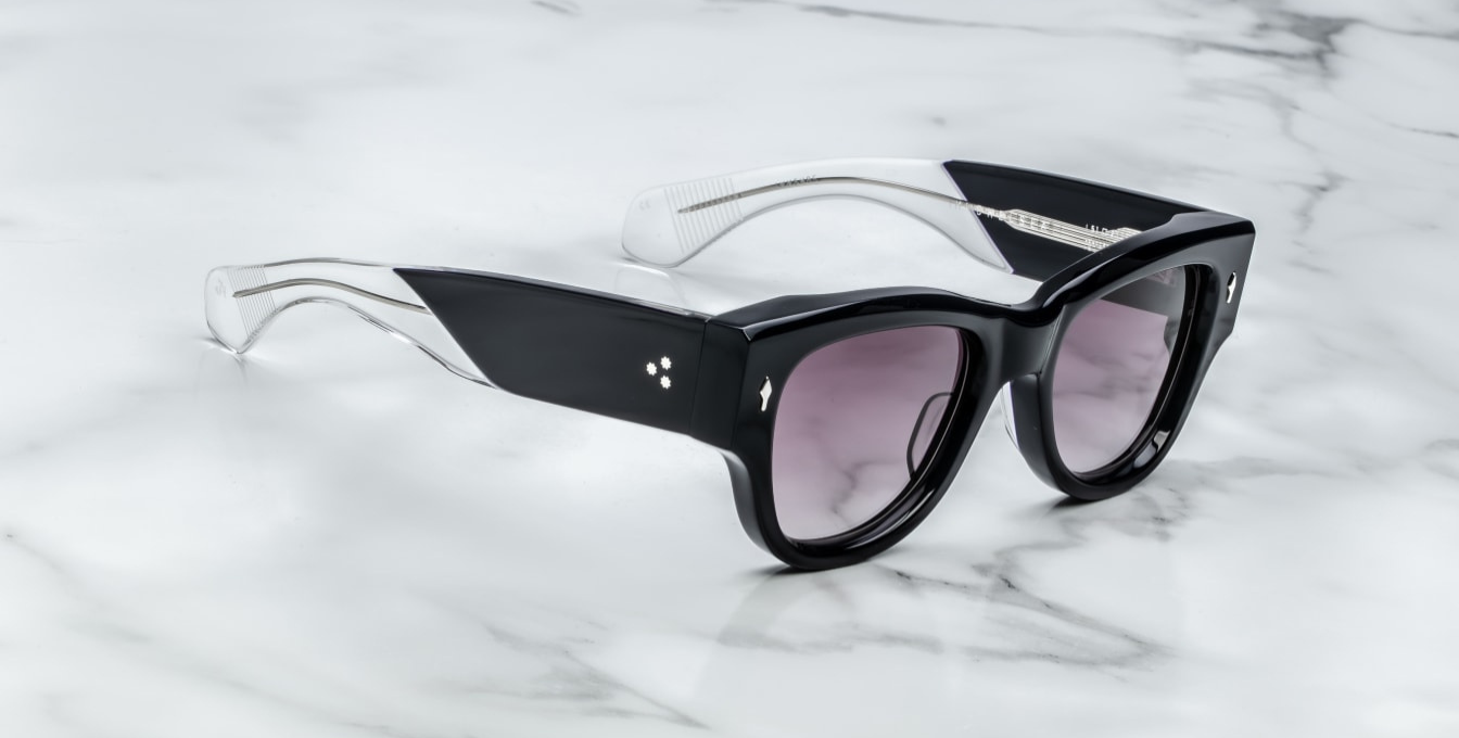 Side profile of Jacques Marie Mage Chelsea sunglasses in Skye, showcasing sculpted paddle temples with exposed sterling silver cantilever wirecore, engraved detailing, and signature arrowhead front pin. Handcrafted in Japan with 10mm double-laminated blue cellulose acetate frame and custom 7-barrel hairline hinges, offering a bold, sculptural silhouette. Wine gradient CR39 lenses provide 100% UV protection and backside anti-reflective treatment