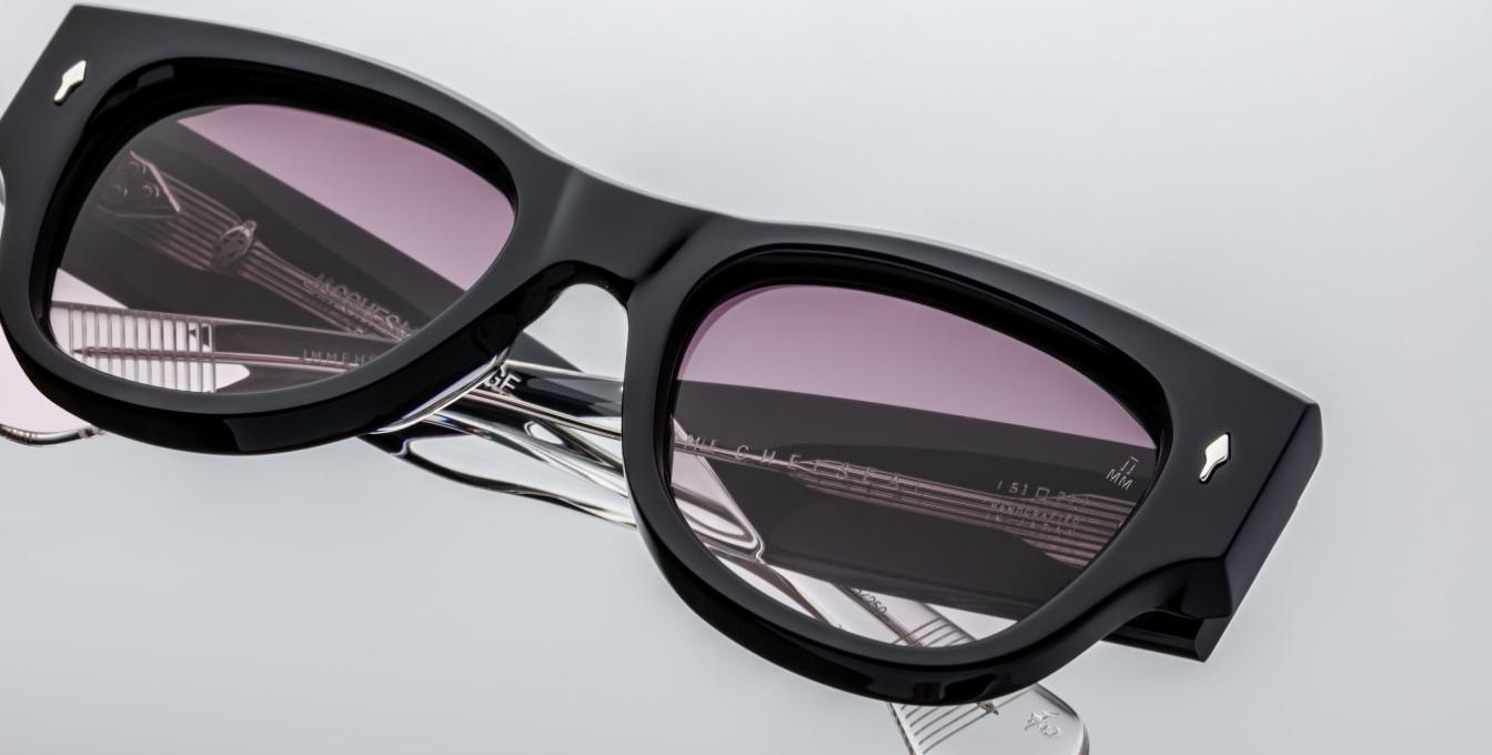 Close-up of the wine gradient CR39 lenses in Jacques Marie Mage Chelsea sunglasses in Skye, offering 100% UV protection and backside anti-reflective treatment. The lenses complement the 10mm double-laminated blue cellulose acetate frame, featuring sculpted paddle temples with exposed sterling silver cantilever wirecore and engraved detailing. Handcrafted in Japan with custom 7-barrel hairline hinges, these lenses provide both style and functionality.