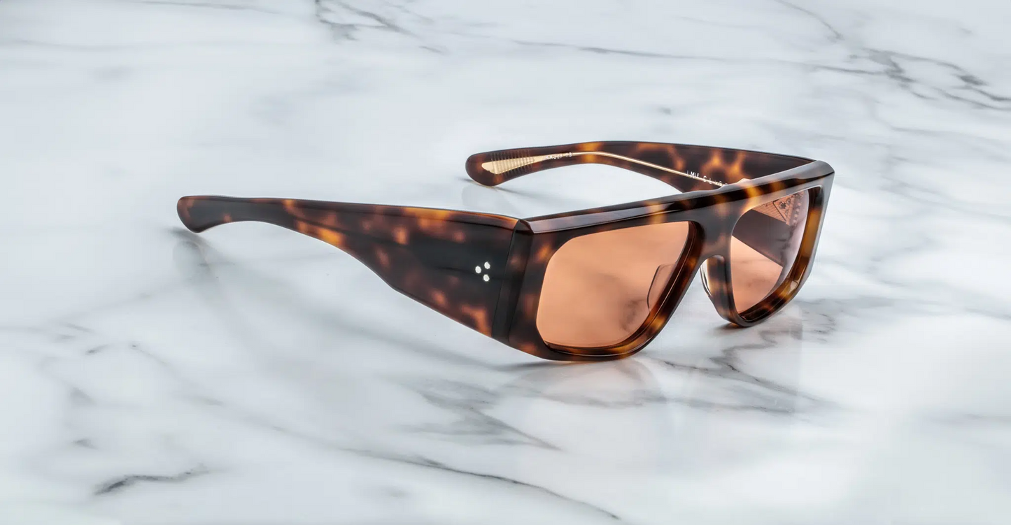 Side view of the Jacques Marie Mage Cliff Havana 7 sunglasses, emphasizing the refined curve of the temples. The temples are adorned with intricate gold-tone metal detailing, reflecting the brand’s signature craftsmanship. The acetate frame is smooth and polished, offering a modern yet classic aesthetic