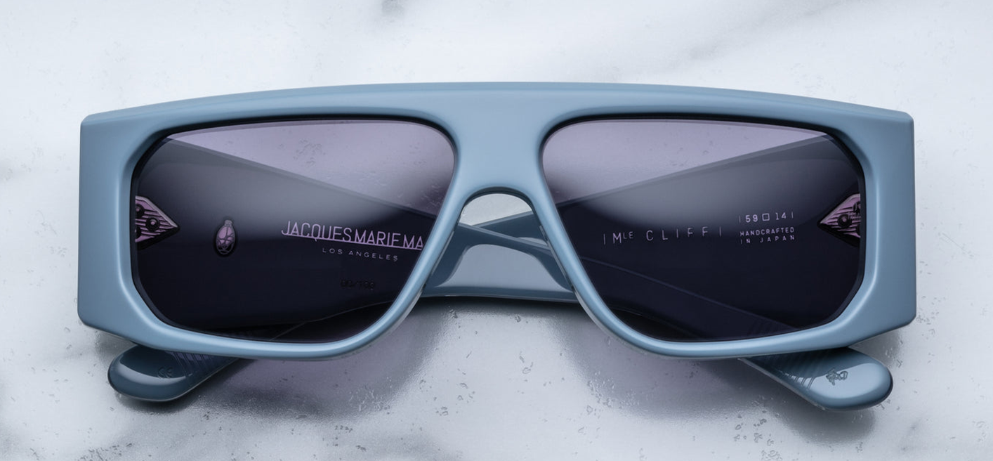 Front view of Jacques Marie Mage Cliff Tiger sunglasses, featuring a bold, square frame in a rich, swirled Tiger acetate pattern with shades of amber, brown, and black. The frame has a striking visual depth, with the natural variations in the acetate adding a unique, luxurious touch. The dark lenses enhance the sophisticated and refined design of the sunglasses