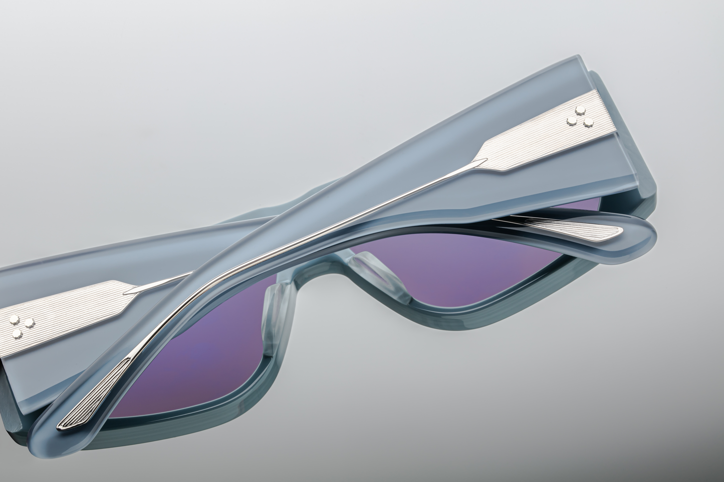 Back view of Jacques Marie Mage Cliff Tiger sunglasses, revealing the intricate swirls of the Tiger acetate finish along the temples. The polished gold-tone metal detailing at the temple tips provides a subtle contrast to the rich, deep hues of the acetate, adding sophistication to the bold design