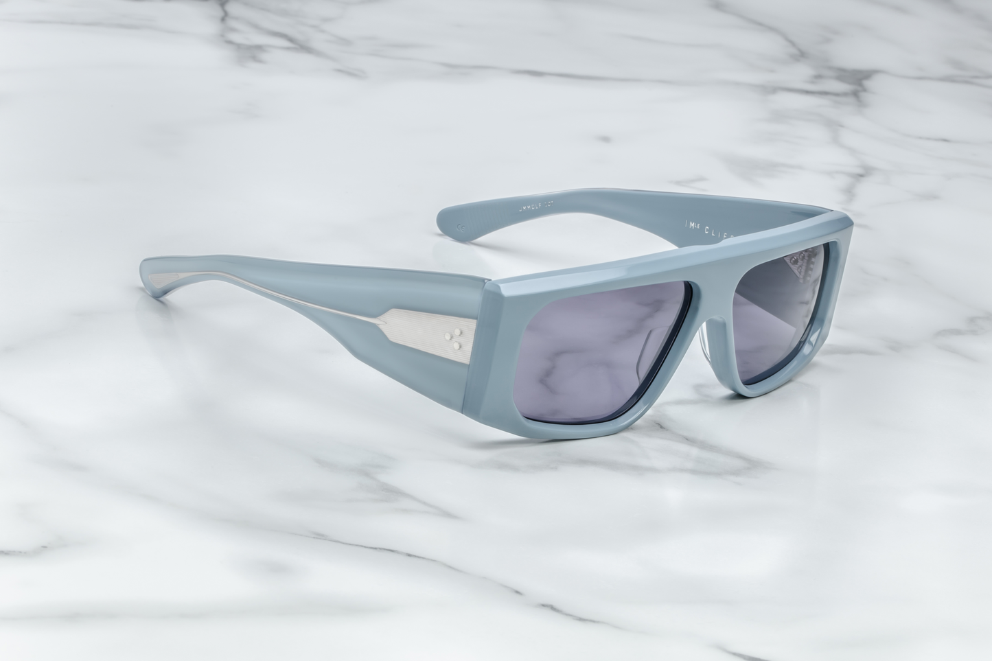 Side view of Jacques Marie Mage Cliff Tiger sunglasses, showcasing the smooth, angular shape of the frame and the carefully sculpted temples. The Tiger acetate finish, with its vivid, marbled patterns, contrasts beautifully with the delicate gold-tone metal accents at the temple ends, elevating the overall luxurious appeal.