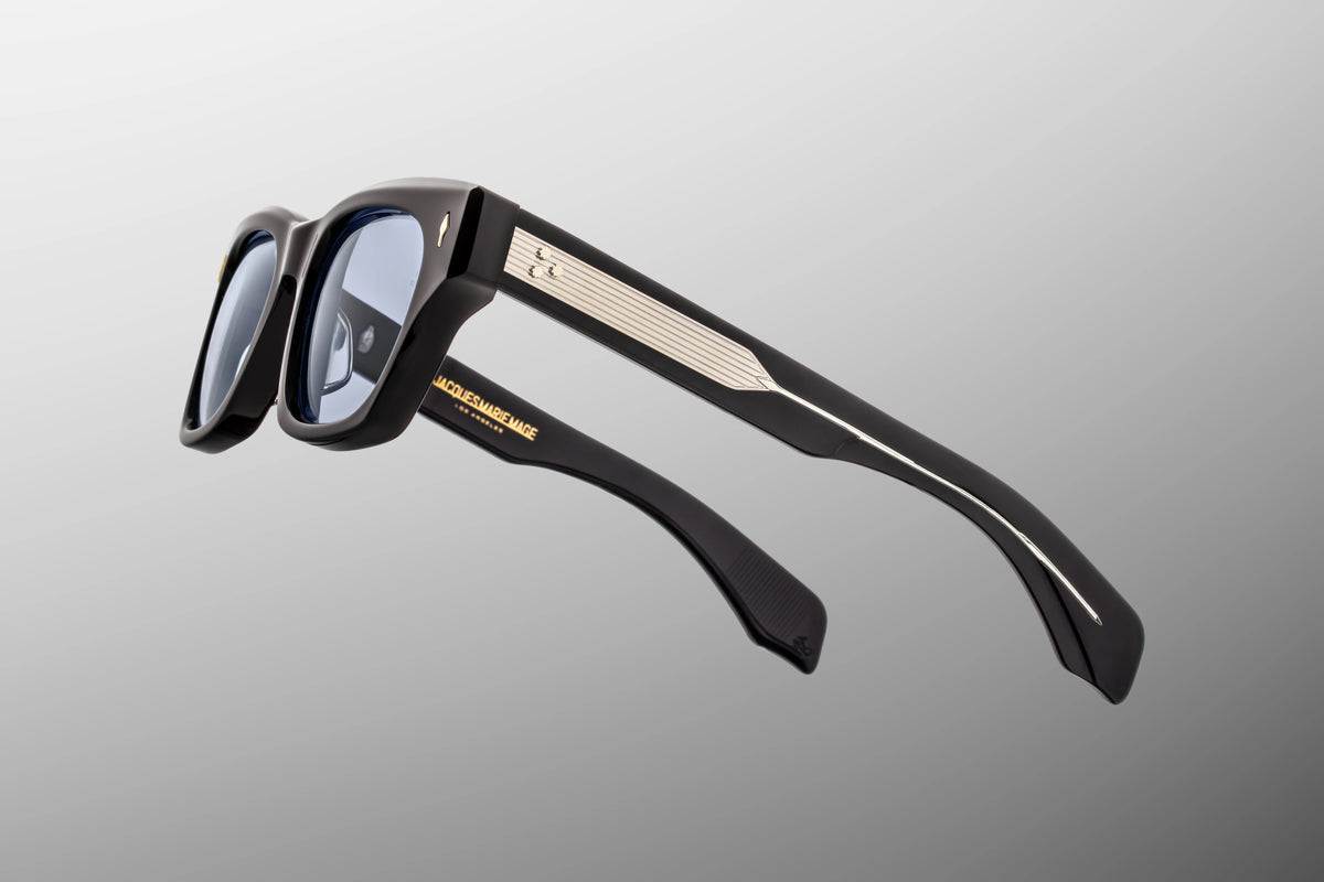 Focused close-up of the 147mm temple arms of the Dealan 53 Obscure glasses. The image details the custom, exposed silver metal wirecore with intricate hairline filigree engravings running through the centre, shimmering visibly through the clear inner laminate of the double-layered blue acetate arm