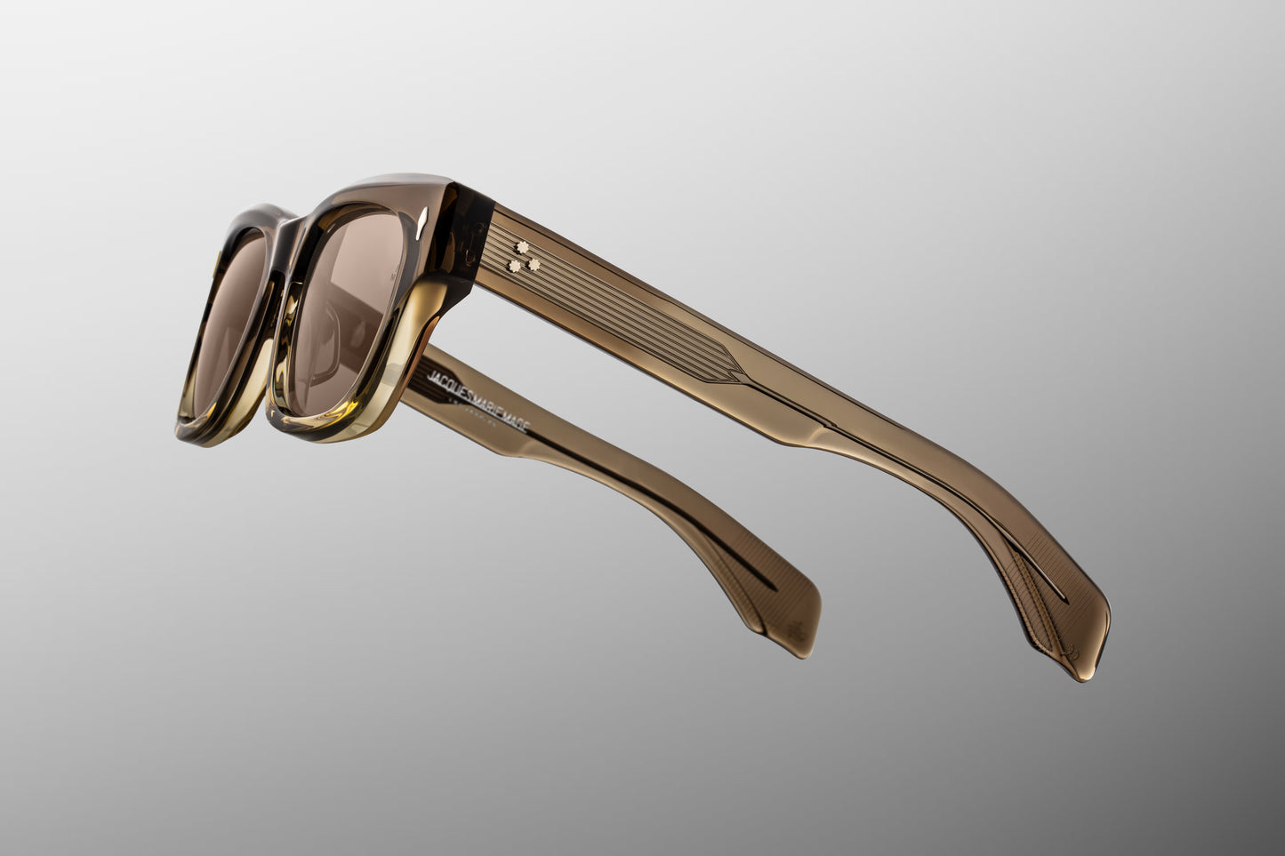 Side profile view of Jacques Marie Mage sunglasses in Lescot, displaying the wide double-laminated acetate temples and the exposed silver custom wirecore with intricate hairline engraving.