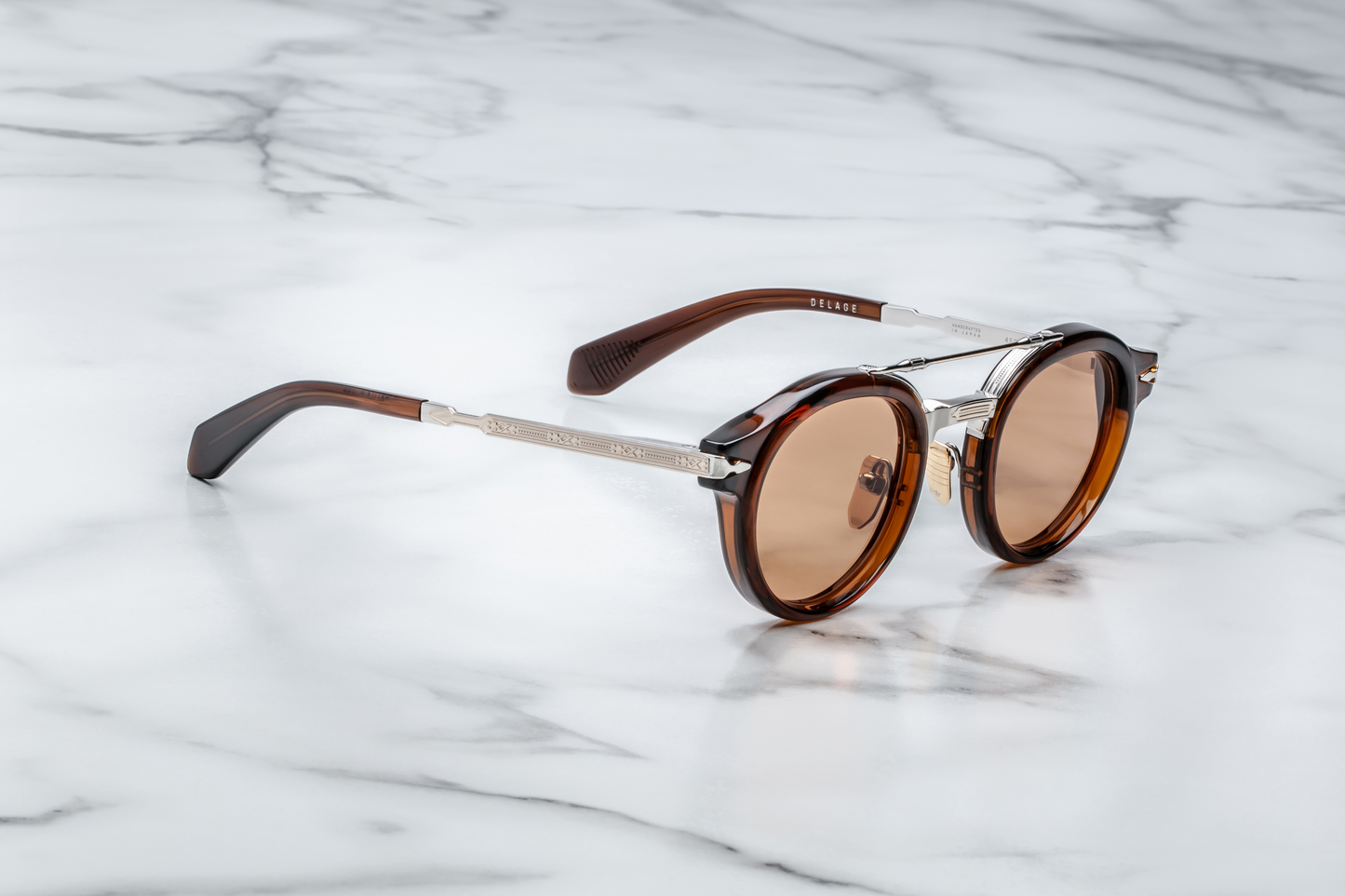 Side profile of Jacques Marie Mage Delage Zoltar highlighting brown acetate temple, fine Art‑Deco engraving, custom arrowhead monoblock hinge in light gold, and exposed sterling‑silver beta‑titanium structure.”