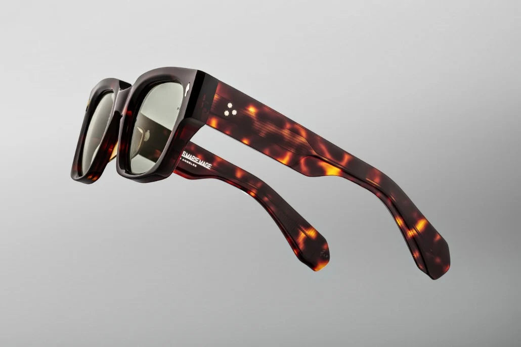 Side view of the JMM Enzo sunglasses temple arm, showcasing the glossy Tenace Havana outer frame, custom double-laminated temples, and sterling silver spur-shaped rivets at the hinge.