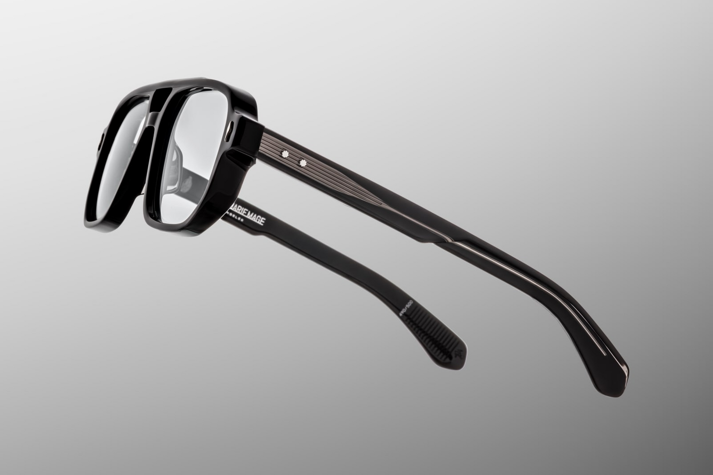 Side profile of Evans Raven showing custom double‑laminated acetate temples with exposed silver wirecore, tension‑secured 7‑barrel hinge adorned by spur‑shaped rivets, and a 3D metal cameo logo