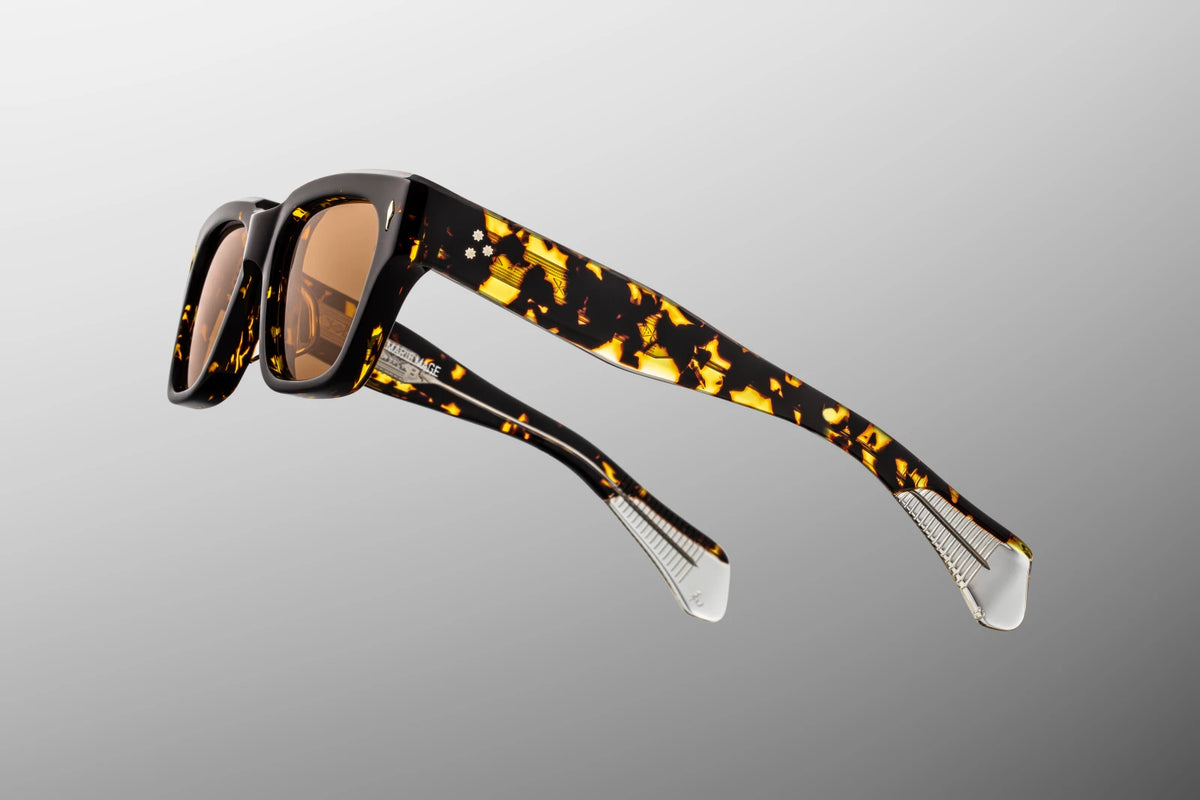 Focused close-up of the 150mm temple arms of the Fellini Tokyo sunglasses. The image emphasizes the custom, exposed "Spiketail" wirecore plated in silver palladium. The inner metal core is meticulously detailed with an intricate hairline-engraved American Southwest motif that shimmers clearly through the transparent inner layer of the double-laminated acetate arm