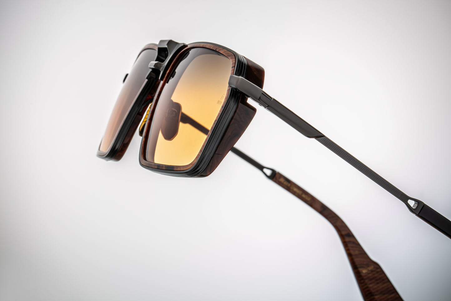 Side view of the frame’s arm and hinge: the Boa sunglasses’ temple is dark (black) and relatively slender, tapering slightly towards the tip. Hinge hardware connects cleanly, showing craftsmanship. The acetate insert wrapping the lens front is visible from this angle, and the gradient shade of the lens is detectable through its slight tilt