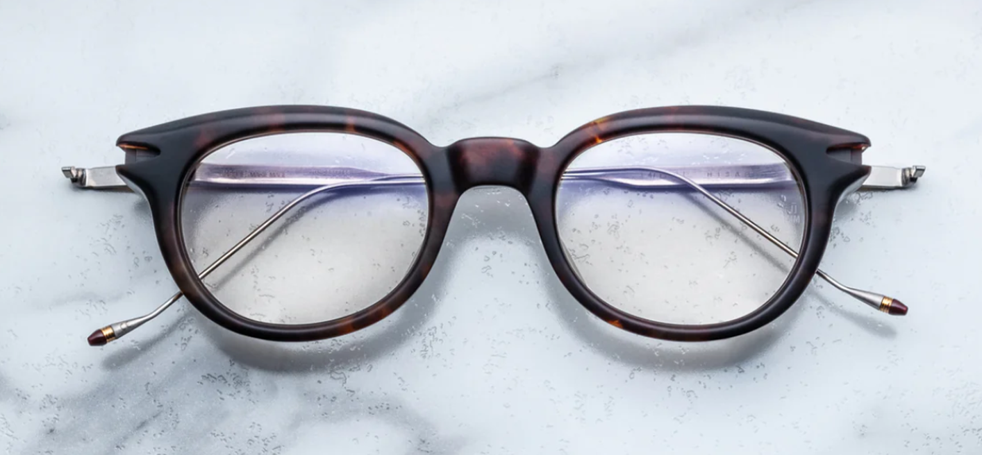 Front view of Jacques Marie Mage Hisao optical glasses in Havana, featuring rectangular amber-brown acetate frames with clear lenses and sculpted detailing