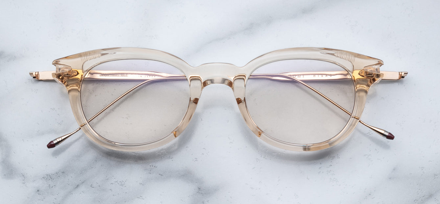 Front view of JMM Hisao in Pearl: oval full‑rim frame in translucent pearl acetate, pale warm tones, clear lenses. Subtle keyhole bridge, thin titanium temples just visible behind rims