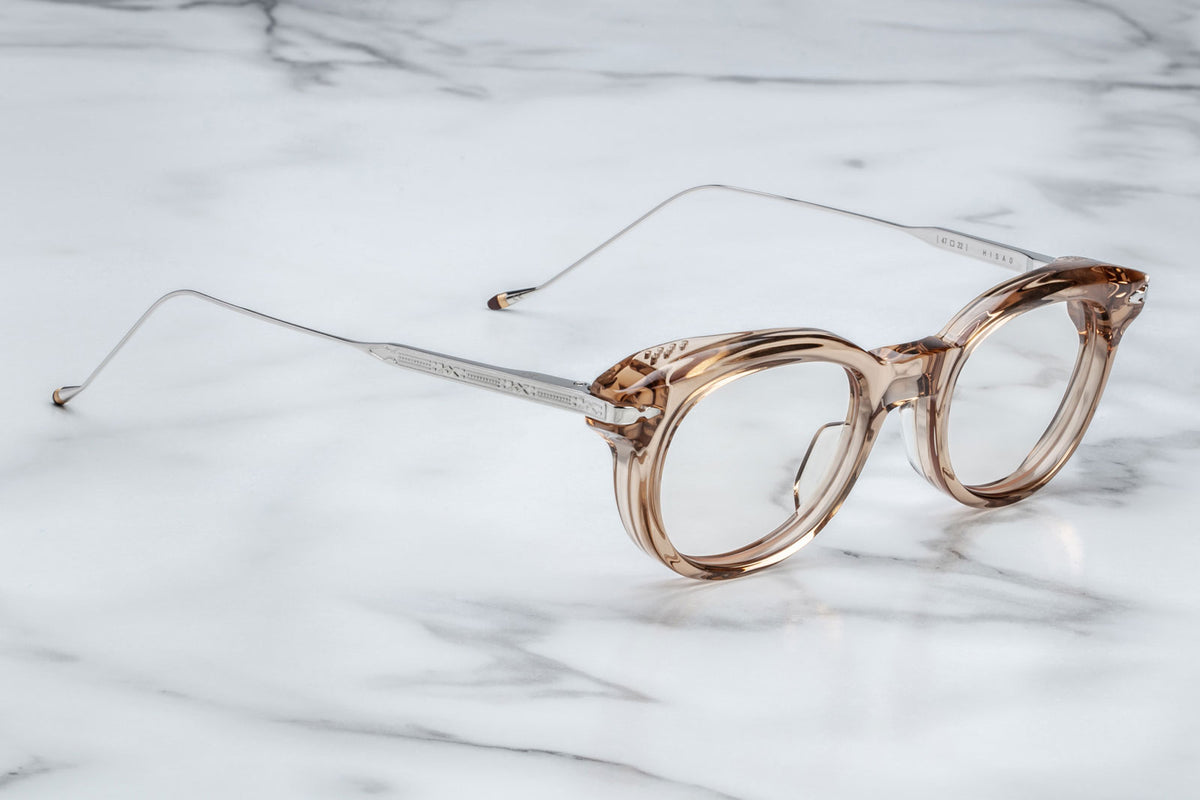 Side view of Jacques Marie Mage Hisao optical glasses in Sand, showing the sculpted temples, signature silver hardware, and warm translucent finish