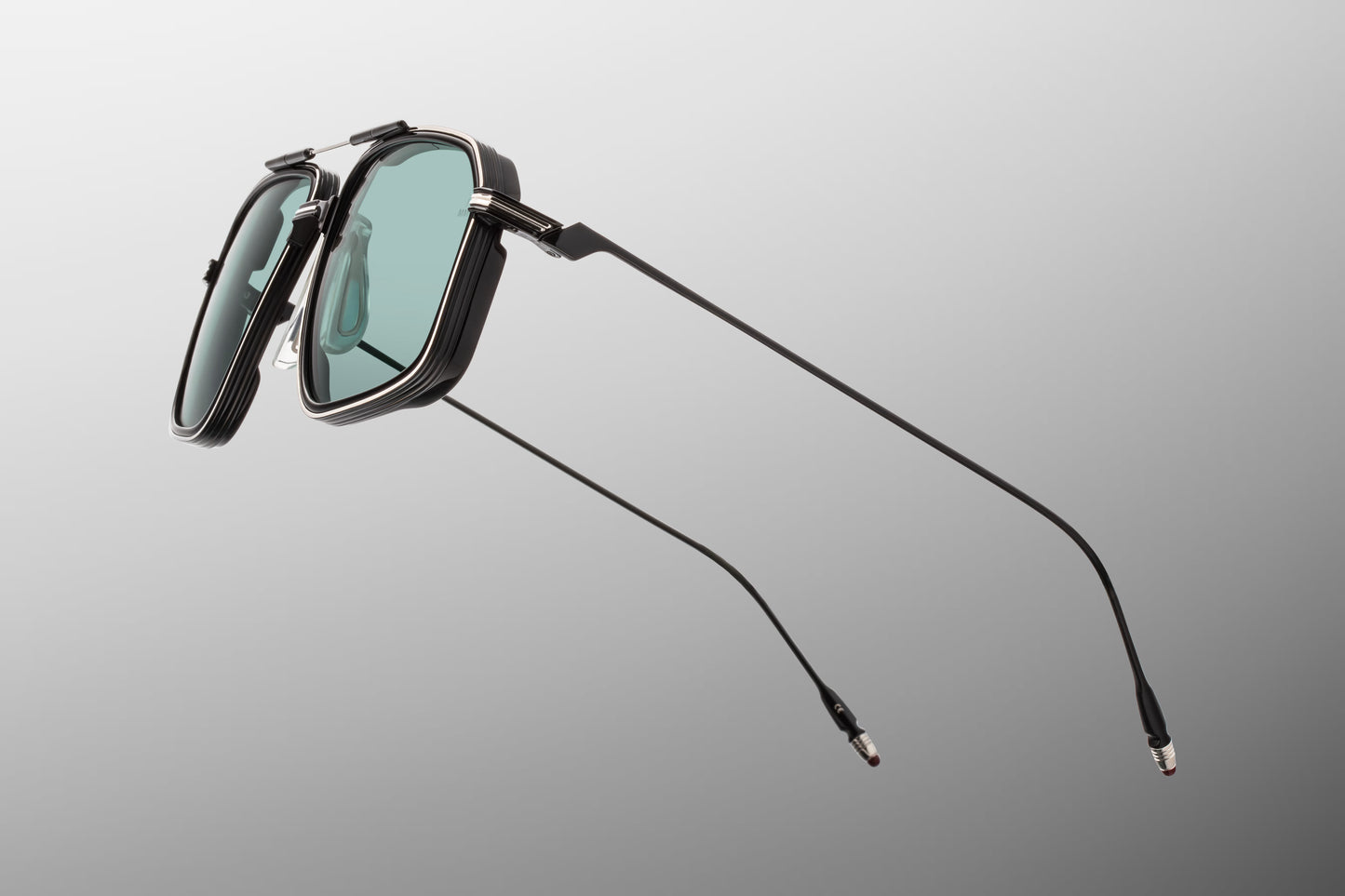 Side view of the JMM Jagger Paon sunglasses temple arm, highlighting the ultra-slim, glossy polished black titanium temples and their seamless transition into the monoblock hinges.
