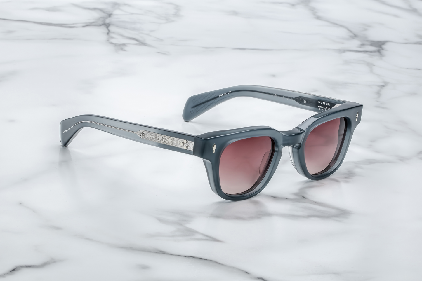 Side view of Julien Mink: double‑laminated acetate temples in matching mink grey, exposed silver wire‑core, tension‑secured 7‑barrel custom hinge, slim silhouette with 143 mm temple length