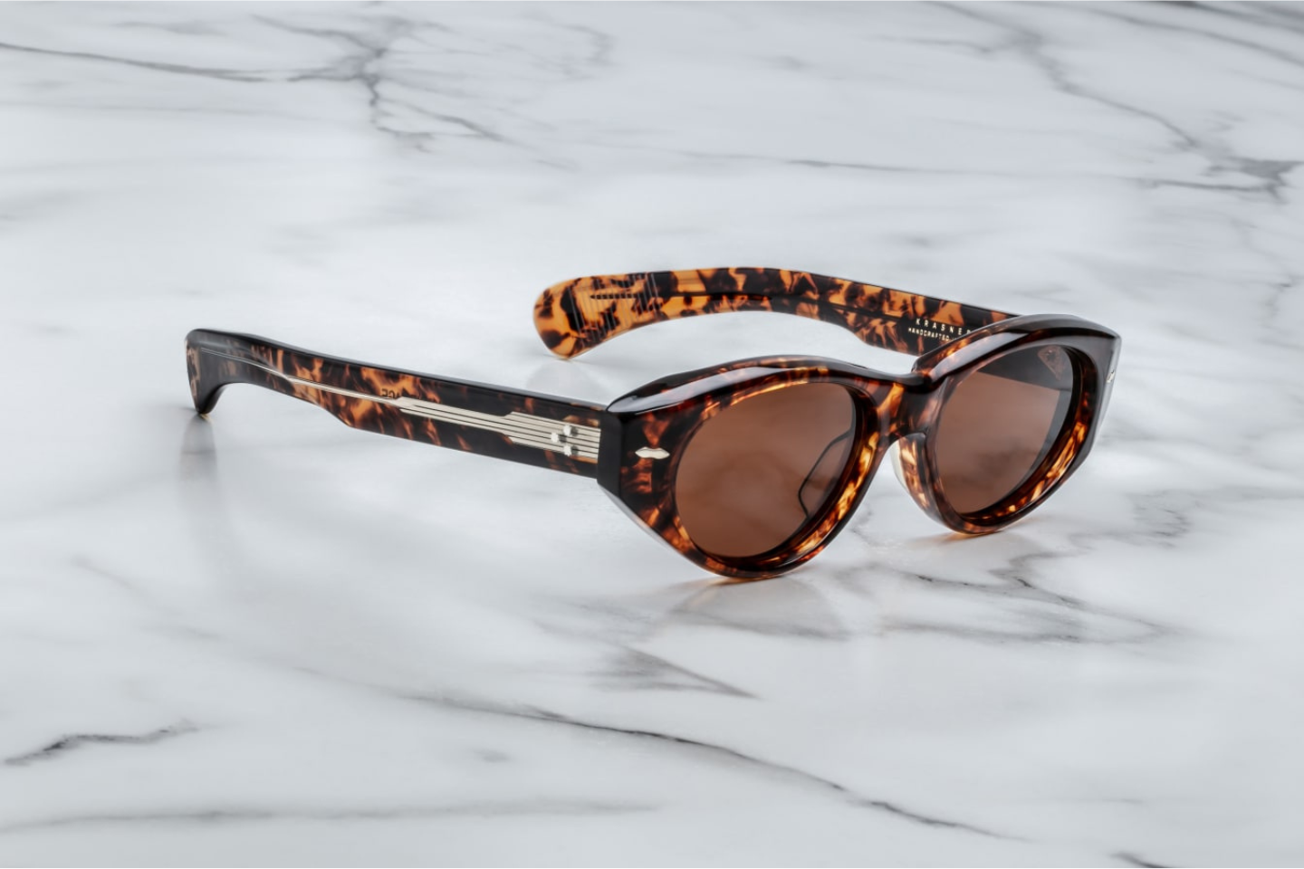 Side profile of Jacques Marie Mage Krasner sunglasses in Samoa, highlighting the custom double-laminated acetate temples with precious metal hardware. The temples feature a silver tension-secured custom 7-barrel hinge, emphasizing the frame's luxurious design