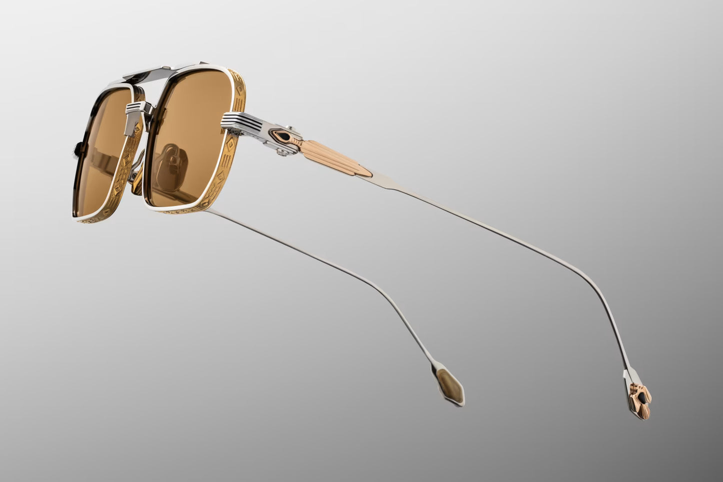 Side profile of JMM Deaver Electrum sunglasses showcasing the ornate temple arms. The silver palladium beta-titanium temples feature dual-tone, 18k gold-plated arrowhead hardware inlaid with ethically sourced white buffalo stone. The temples are finished with gold epoxy accents and fixed by a precision custom hinge