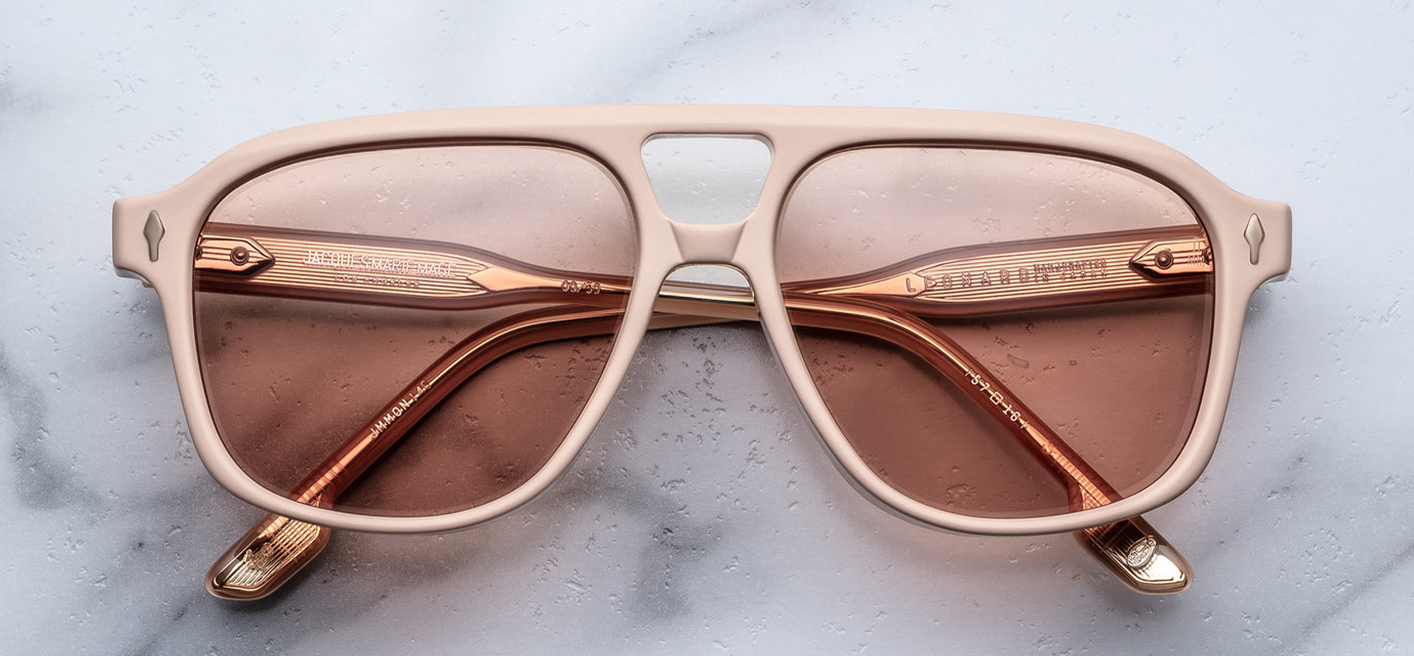 Front view of Jacques Marie Mage Leonard Suede sunglasses in Dust Suede: oversized navigator-style frame in matte orange cellulose acetate, featuring a balanced double-bridge design. The frame includes light gold arrowhead front pins and Vauxhall wirecores with refined hairline details