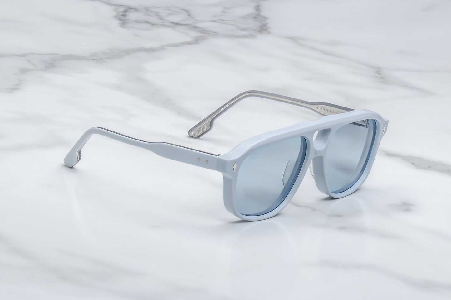 Side profile of Jacques Marie Mage Leonard Suede sunglasses in Sky Suede: showcases the thick acetate front transitioning into slim, sculpted temple arms. The temples are custom double-laminated acetate with sterling silver metal accents and Vauxhall wirecore exposed along the inner edge.