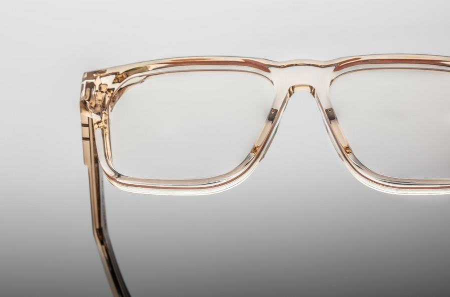 A front close-up of the Lucknow | Pearl frame in translucent crystal acetate. It highlights the thick 10 mm rectangular front with sculptural volume cuts, flowing into double-laminated temple