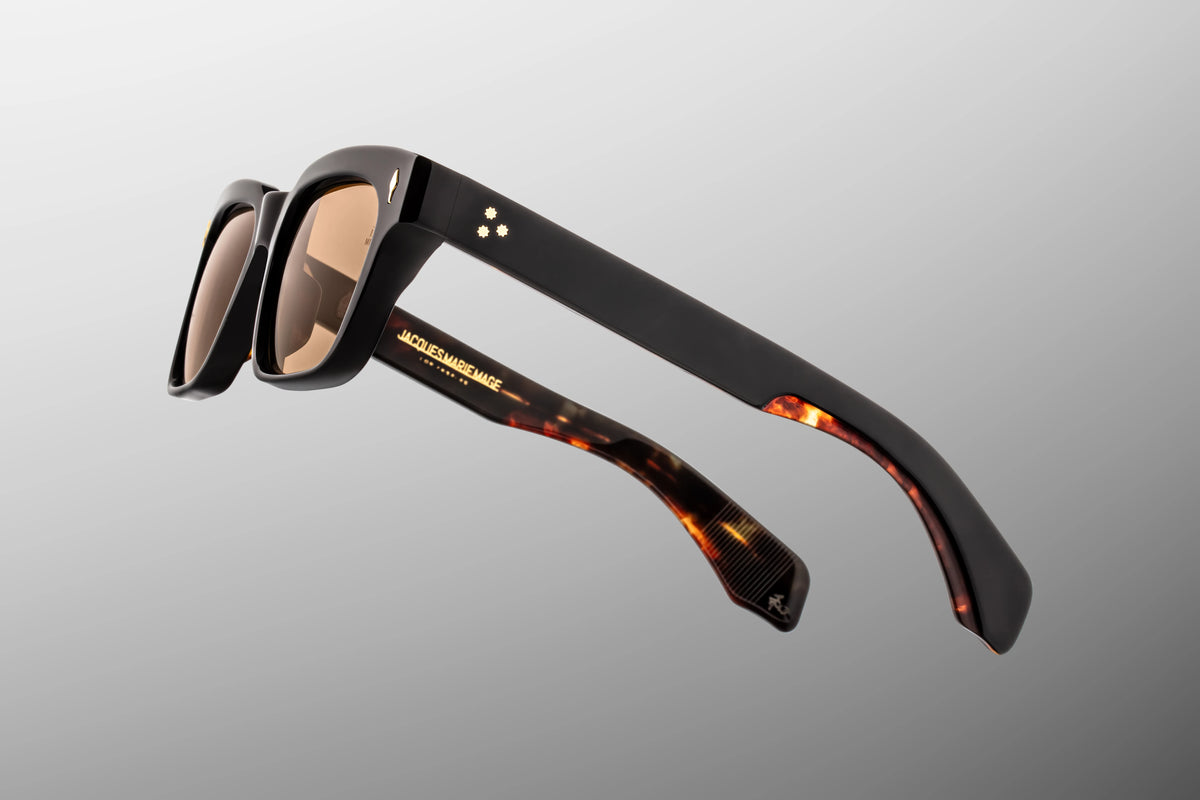 Macro shot of the inner temple arm on Jacques Marie Mage Molino Noir 15 sunglasses. The crystal-clear interior laminate acts as a window to show off the silver palladium wire core engraved with intricate hairline filigree.