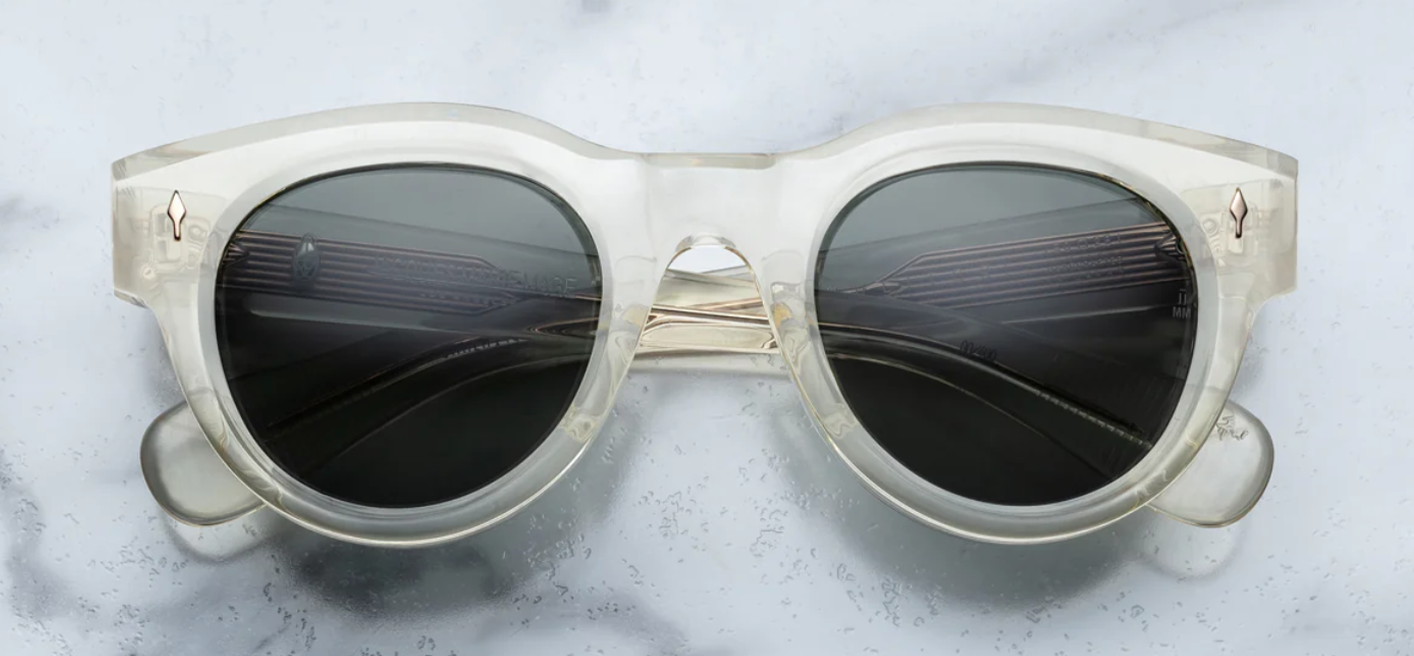 Jacques Marie Mage Molitor Brut Spruce sunglasses, featuring a bold rectangular silhouette with a pronounced browline. The frame is crafted from 10mm polished cured cellulose acetate in a crystal finish, complemented by light gold accents. The lenses are Spruce green CR39 with a 6-base curve and backside anti-reflective coating, offering 100% UV protection.