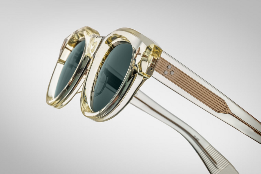 A detailed shot focusing on the temple of the Molitor Brut Spruce sunglasses, revealing the custom double-laminated acetate construction with a light gold wirecore. The temples feature Jacques Marie Mage's signature arrowhead pin design, adding a unique and recognizable touch.