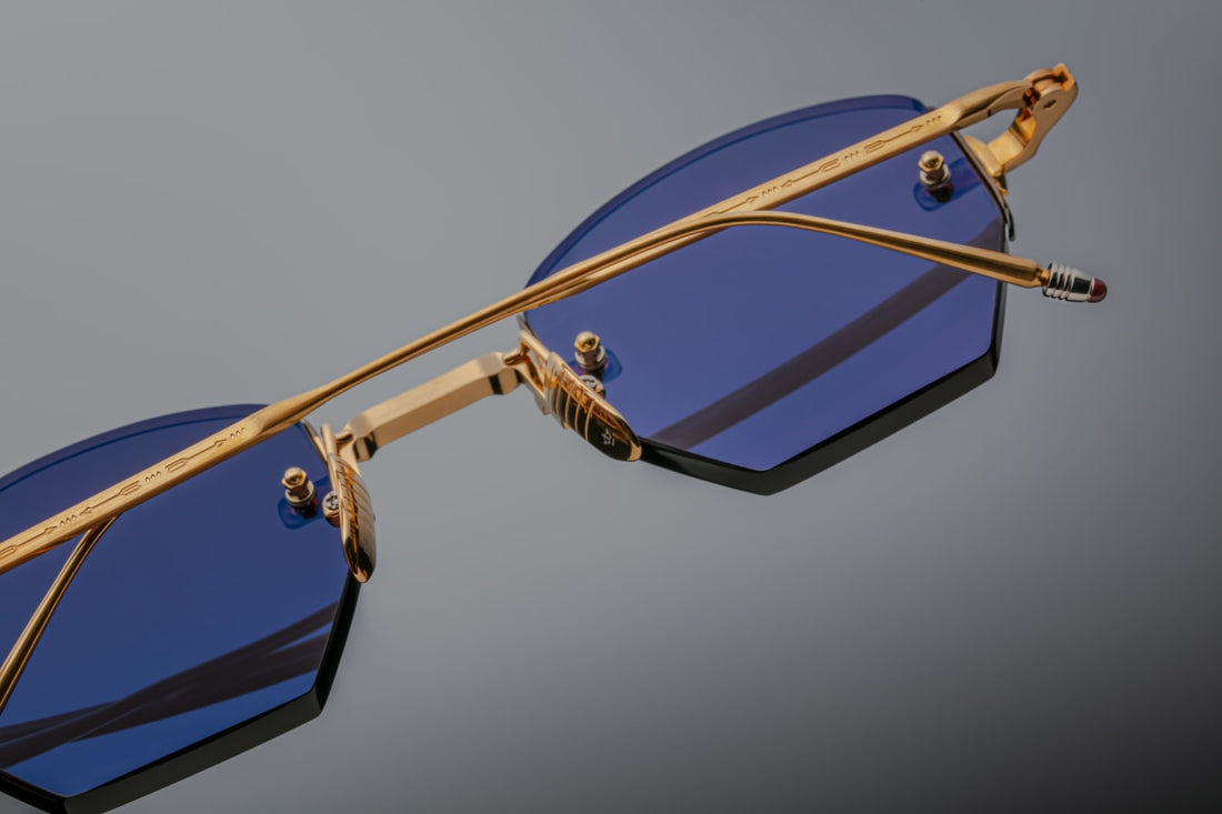 Underside shot showing inner structure: polished gold bridge and recessed hinge housing. Temple interior displays stamped specs (48–25–141), serial number, ‘Handmade in Japan’, and JMM branding in fine laser engraving. Bone hinge and integrated wire-core stand revealed in cross-section.