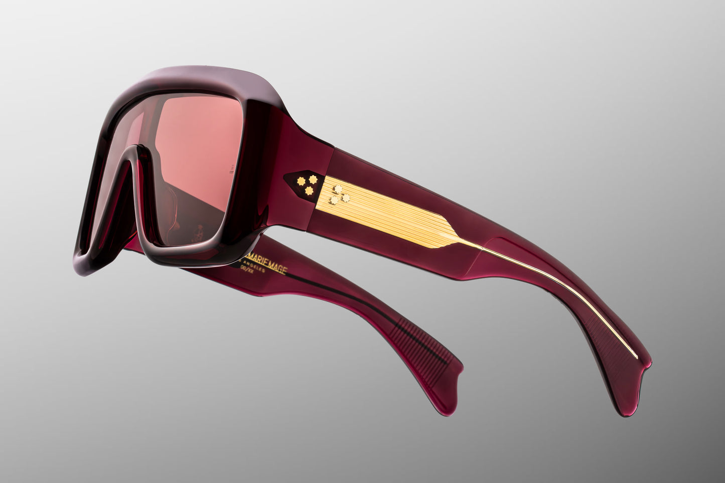 Close-up side detail of Jacques Marie Mage Pausa Amarena showing engraved gold wire core, hinge construction and layered acetate temples
Macro side view of JMM Pausa Amarena sunglasses highlighting premium hardware and temple detailing