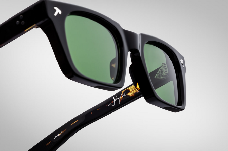 Three-quarter angled view of Jacques Marie Mage Johnny Cash II Quentin sunglasses in Noir 9: emphasizes the bold, structured silhouette with a slight upward curve at the temples. The deep black finish contrasts with the polished silver accents, highlighting the craftsmanship.