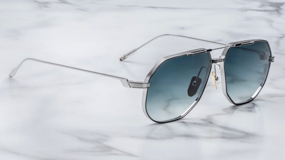 Side view the Jacques Marie Mage Reynold Pacific an oversized, ’70s-inspired titanium aviator in silver and black 100% beta titanium frame , engraved double bridge, signature tail‑fin temples with blue gradient lenses. Limited to j500 handcrafted pieces. WINK Optometrists