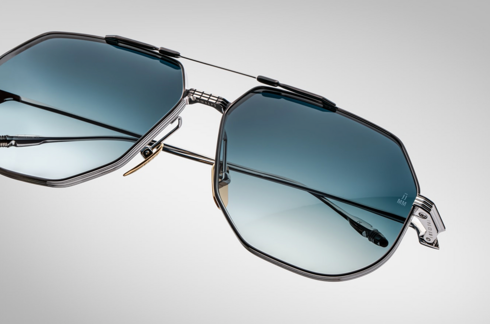 Close detail of the Jacques Marie Mage Reynold Pacific an oversized, ’70s-inspired titanium aviator in silver and black 100% beta titanium frame , engraved double bridge, signature tail‑fin temples with blue gradient lenses. Limited to j500 handcrafted pieces. WINK Optometrists