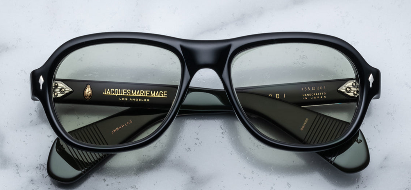 Jacques Marie Mage Richard Cobra sunglasses, showcasing a modern aviator silhouette with a flat browline and wide temples. The frame is crafted from 10mm black cured cellulose acetate, featuring sterling silver arrowhead front pins and exposed wirecore details. The light bottle green CR39 lenses offer 100% UV protection and backside anti-reflective treatment.