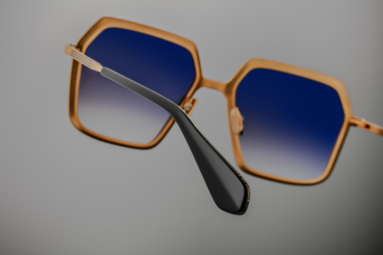 Back view of Jacques Marie Mage Ugo Gold sunglasses, showcasing the gold-toned beta titanium frame with sculpted hexagonal volumes and hairline epoxy detailing. The acetate temple tips with exposed wirecore details are prominently displayed