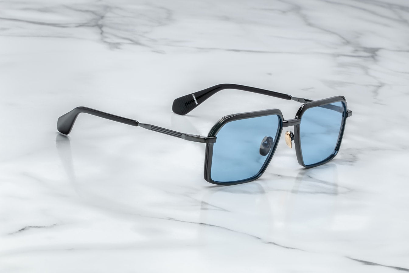 ide profile of Jacques Marie Mage Vasco Black sunglasses, highlighting the sleek black titanium frame with sculpted volume cuts and hairline epoxy detailing. The acetate temple tips with exposed wirecore details are visible, emphasizing the frame's modern design