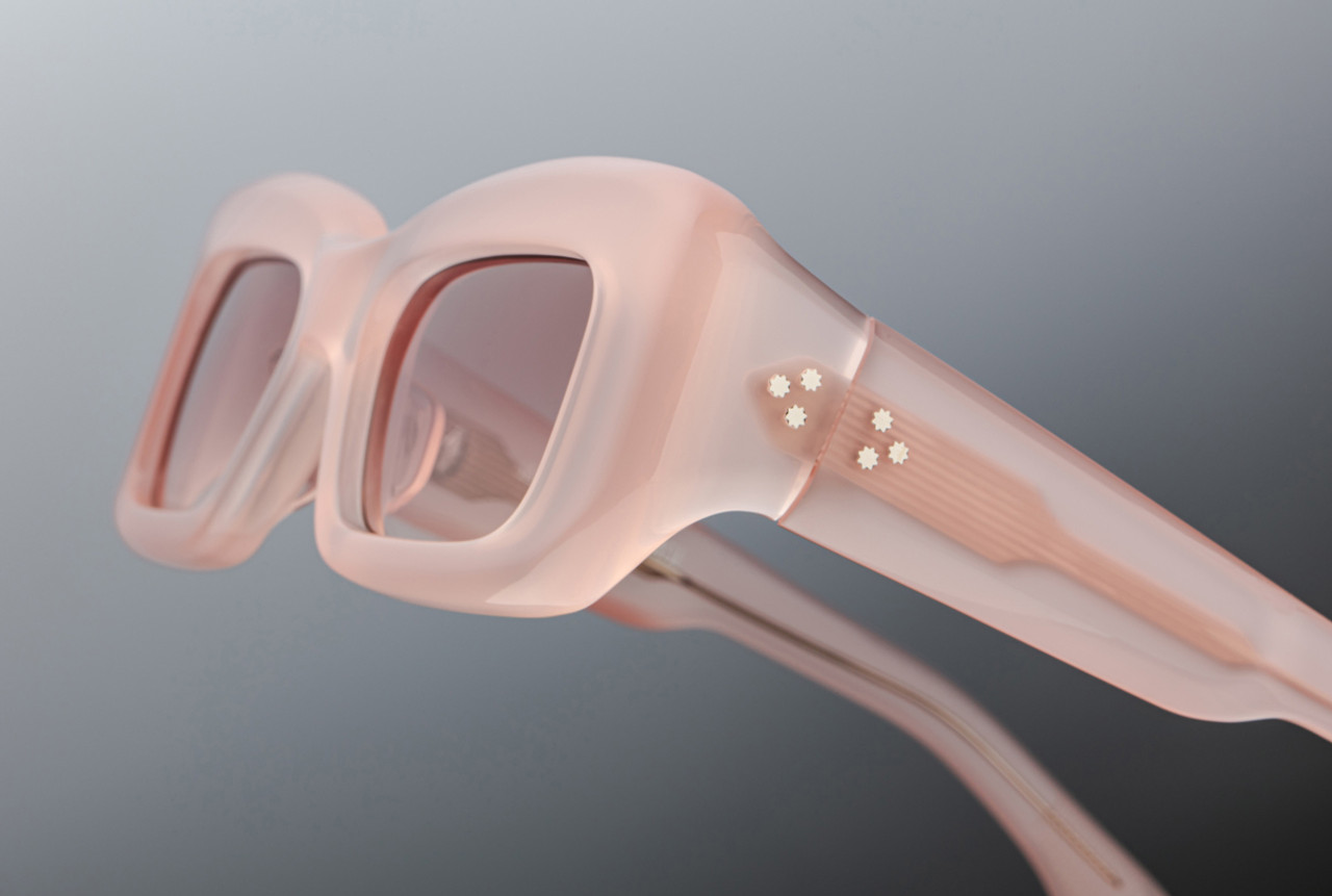 Side profile of Jacques Marie Mage Vito eyeglasses in a soft translucent peach acetate, showcasing sculptural temple arms with silver arrowhead hinge pins and subtle filigree detailing within the acetate. The temples taper gently behind the ear for both style and comfort.