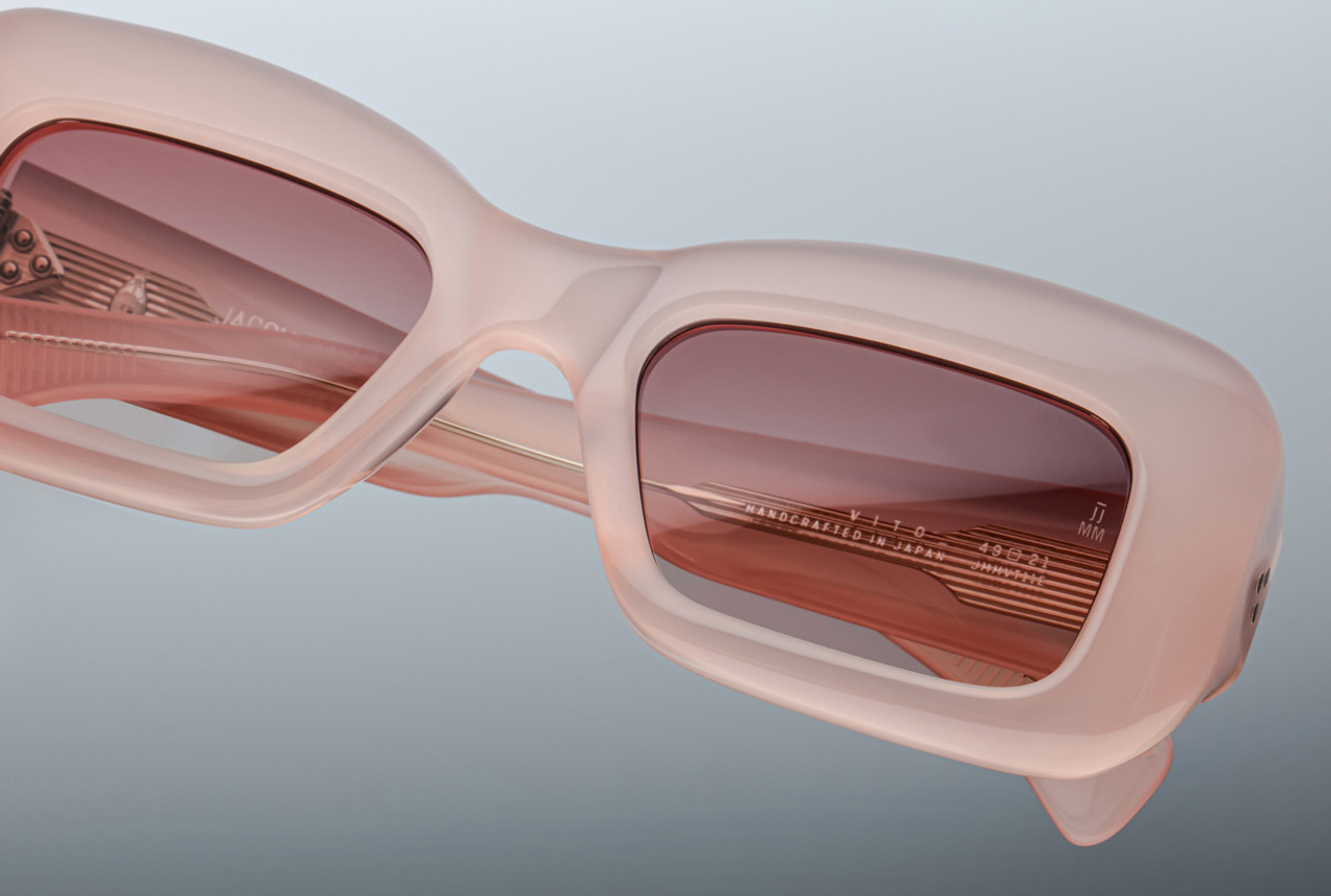 Lens area of the Jacques Marie Mage Vito eyeglasses in Peach, featuring a bold geometric browline and thick rims in warm translucent acetate. The sharp lines and high bridge design give the frame a distinct architectural silhouette.