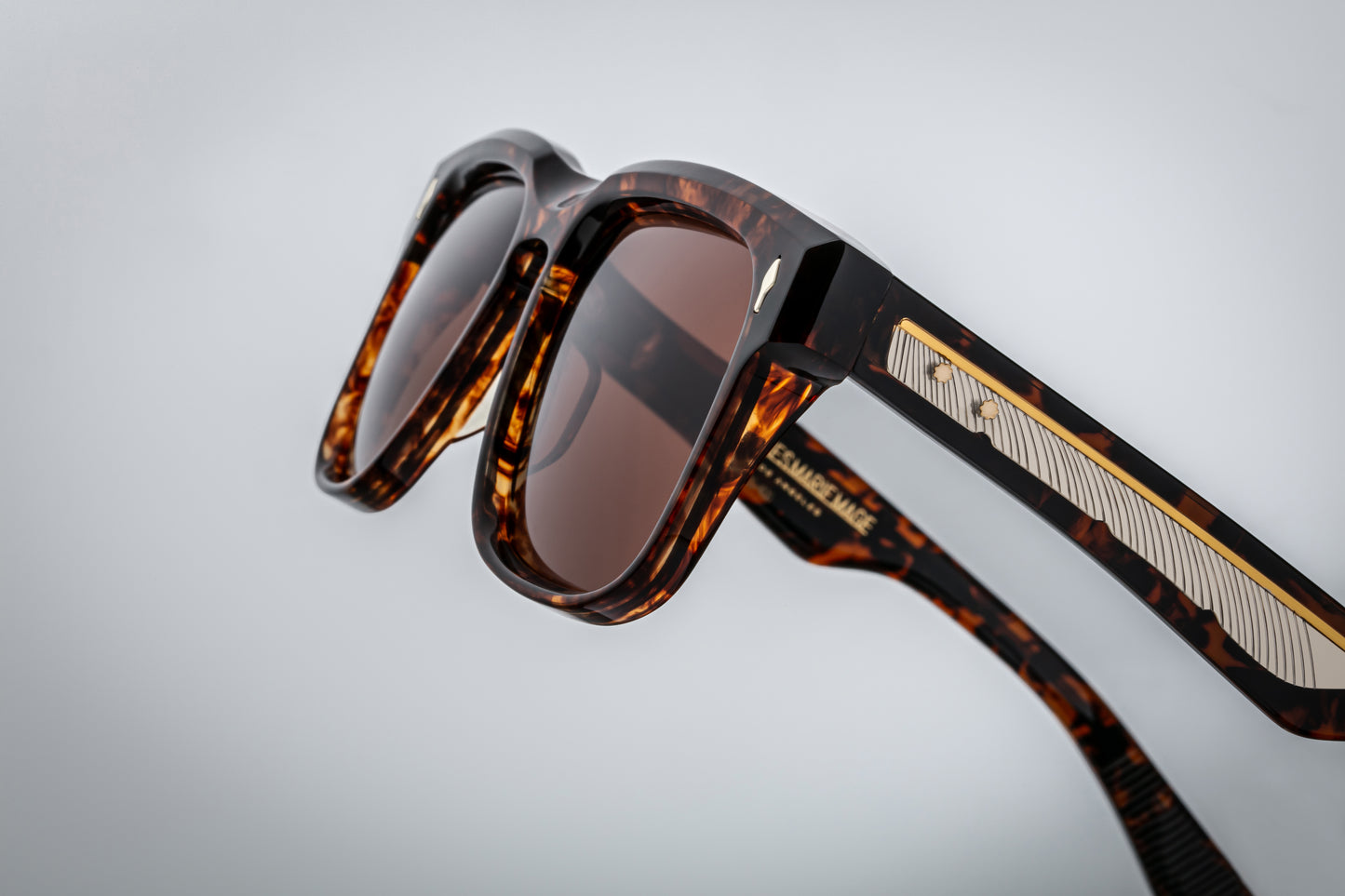 Close-up of the Wesley Samoa hinge — dark-gold custom 5-barrel tension-plated hinge with spur rivets and exposed engraved wire-core