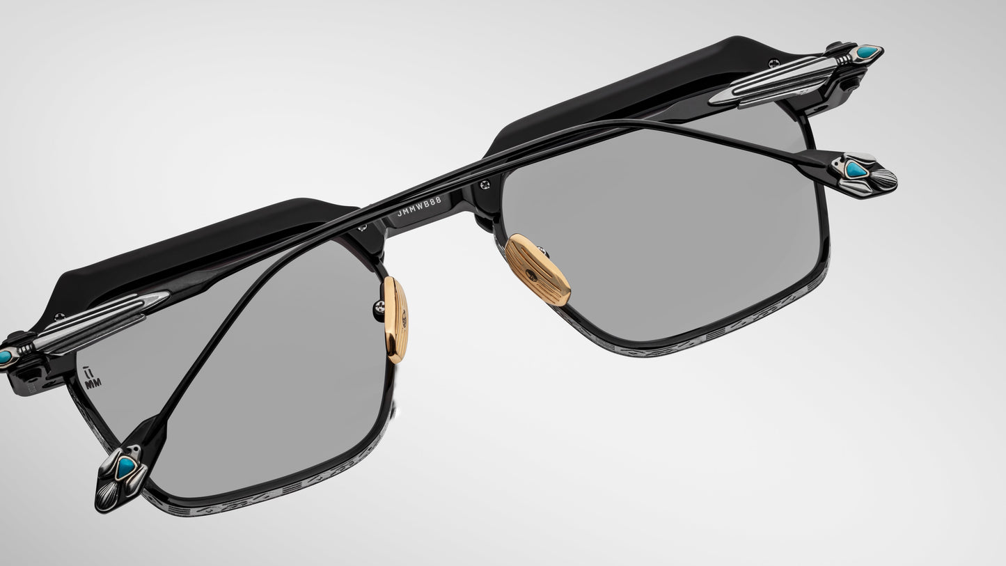 Sunglasses with black frames and reflective lenses on a light gray background