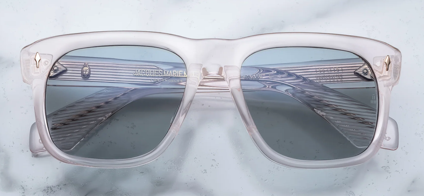 Clear sunglasses with reflective lenses on a light blue background