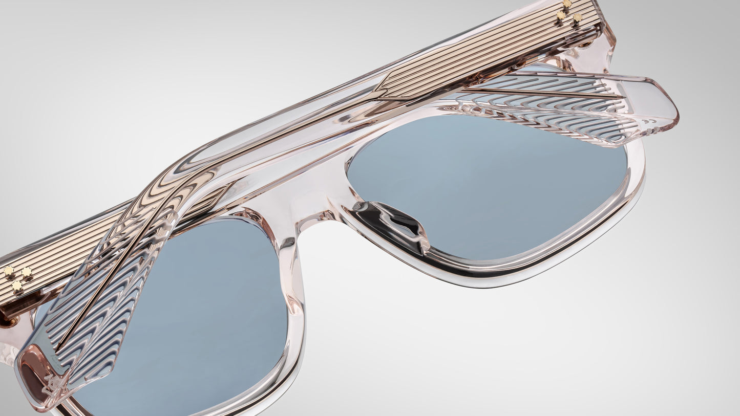 Sunglasses with transparent frame and blue lenses on a gray background
