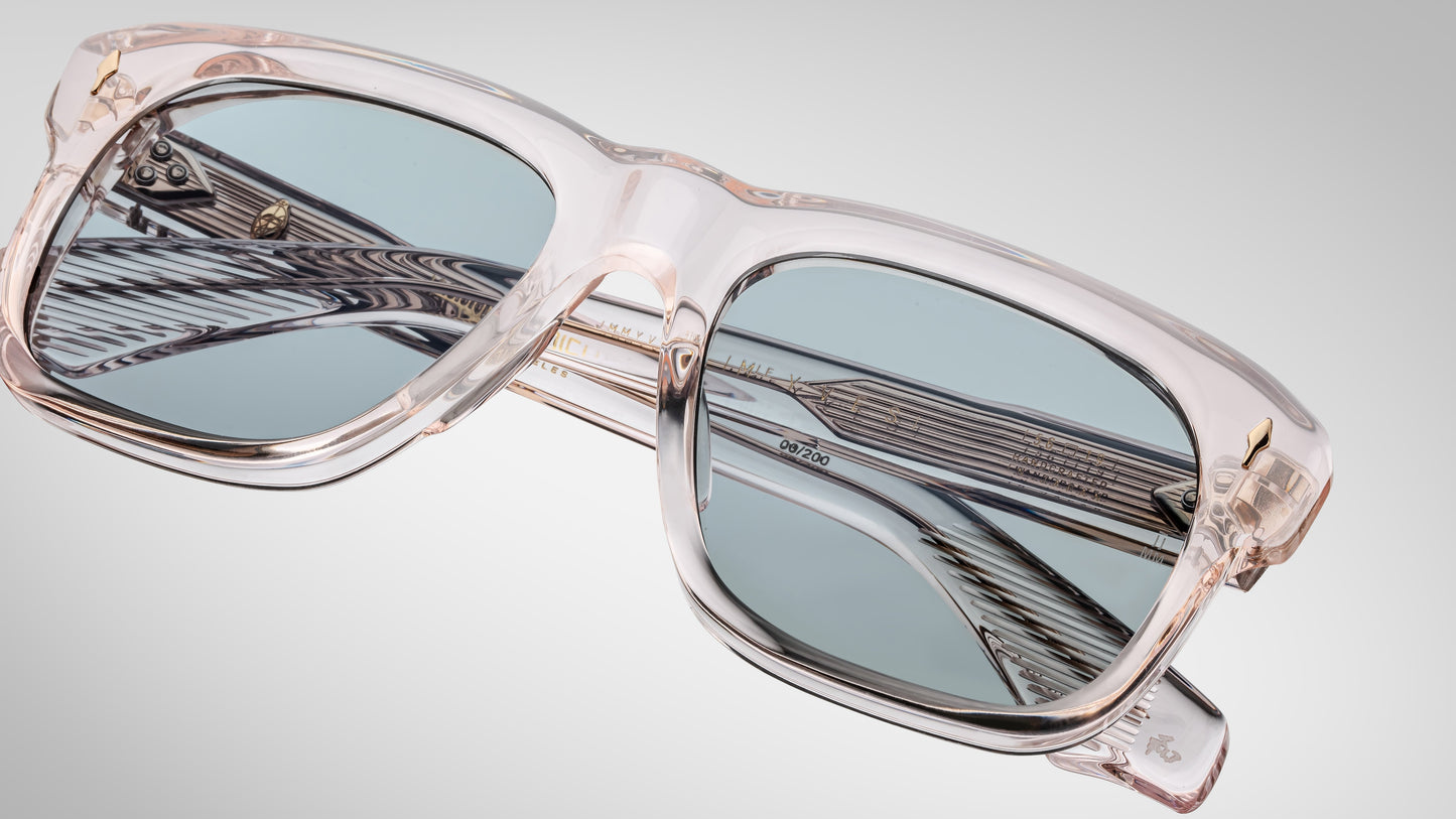 Sunglasses with clear frame and blue-tinted lenses on a light gray background
