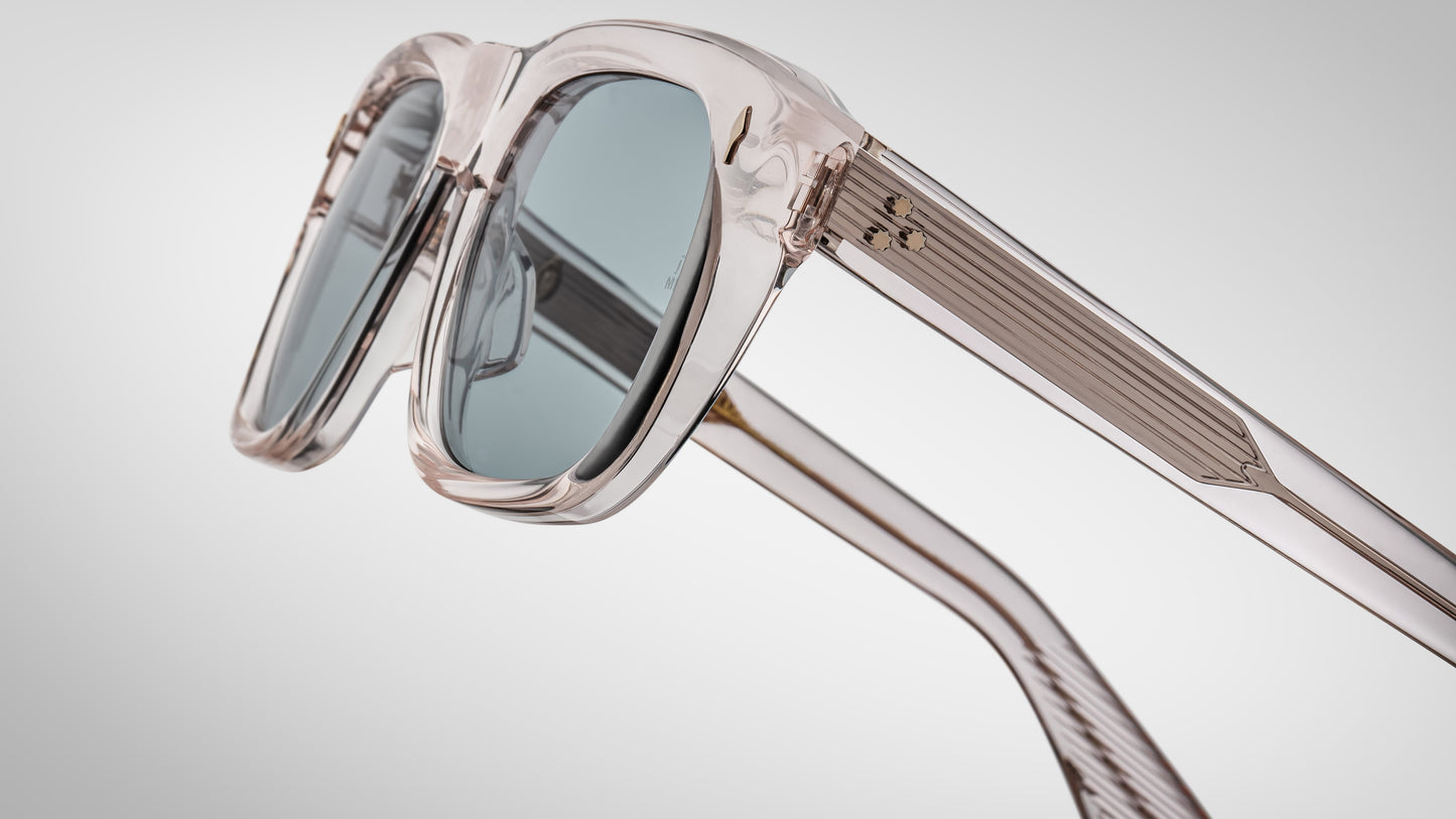 Sunglasses with clear frame and reflective lenses on a light gray background
