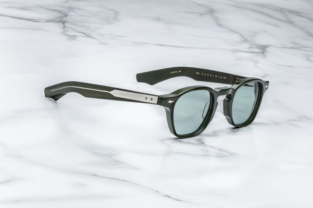 Side view of Zephirin Evergreen by Jacques Marie Mage: sculpted double‑laminated acetate temples in matching evergreen green, exposed silver wire‑core, signature sterling silver arrowhead front pin, tension‑secured custom 5‑barrel hinge with spur‑shaped sterling silver rivets