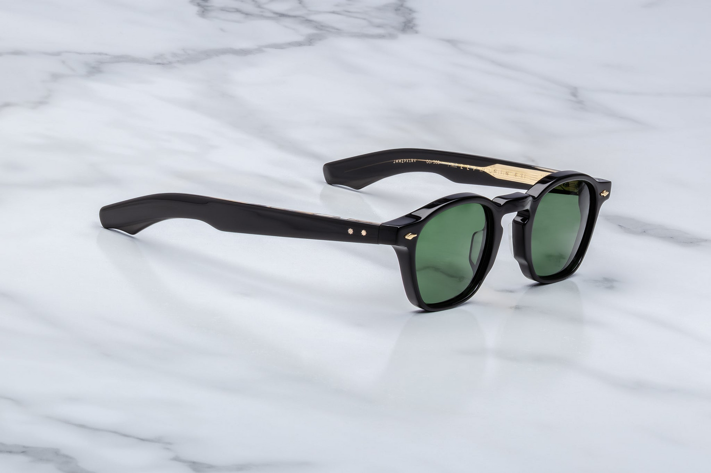 Side view of Zephirin Venom by Jacques Marie Mage: layered acetate temples with mix of military green and black veneer, exposed wire‑core construction, engraved ‘JMM’ logo on temple, sculpted hinge design accentuating Venom colorway