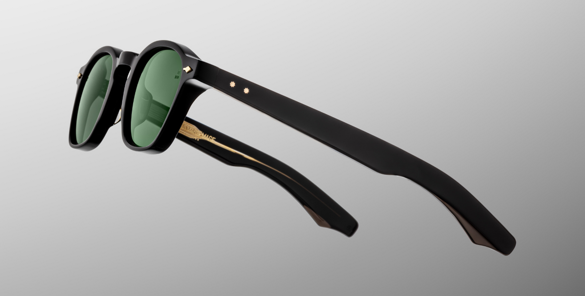 Side view of Zephirin Venom by Jacques Marie Mage: layered acetate temples with mix of military green and black veneer, exposed wire‑core construction, engraved ‘JMM’ logo on temple, sculpted hinge design accentuating Venom colorway.