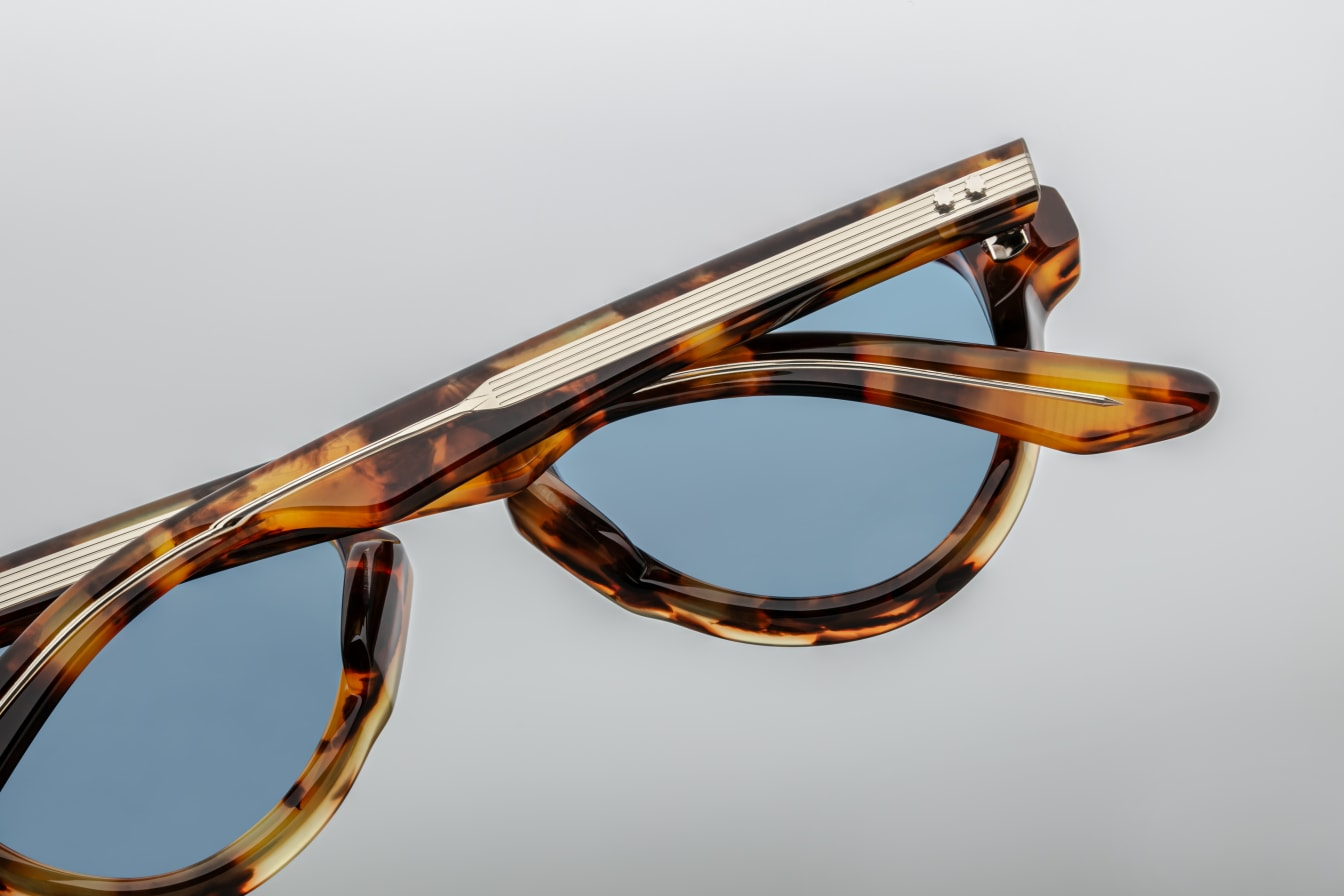 Back view of Jacques Marie Mage Hatfield sunglasses in Havana 8, featuring a bold 10mm double-laminated cured cellulose acetate frame with custom double-laminated temples. The design includes sterling silver arrowhead front pins, an exaggerated teardrop aviator shape, exposed silver wirecore with custom hairline engraving, and silver tension-secured custom 5-barrel hinges. The blue CR39 lenses offer 100% UV protection and backside anti-reflective coating. Available at WINK OPtometrists